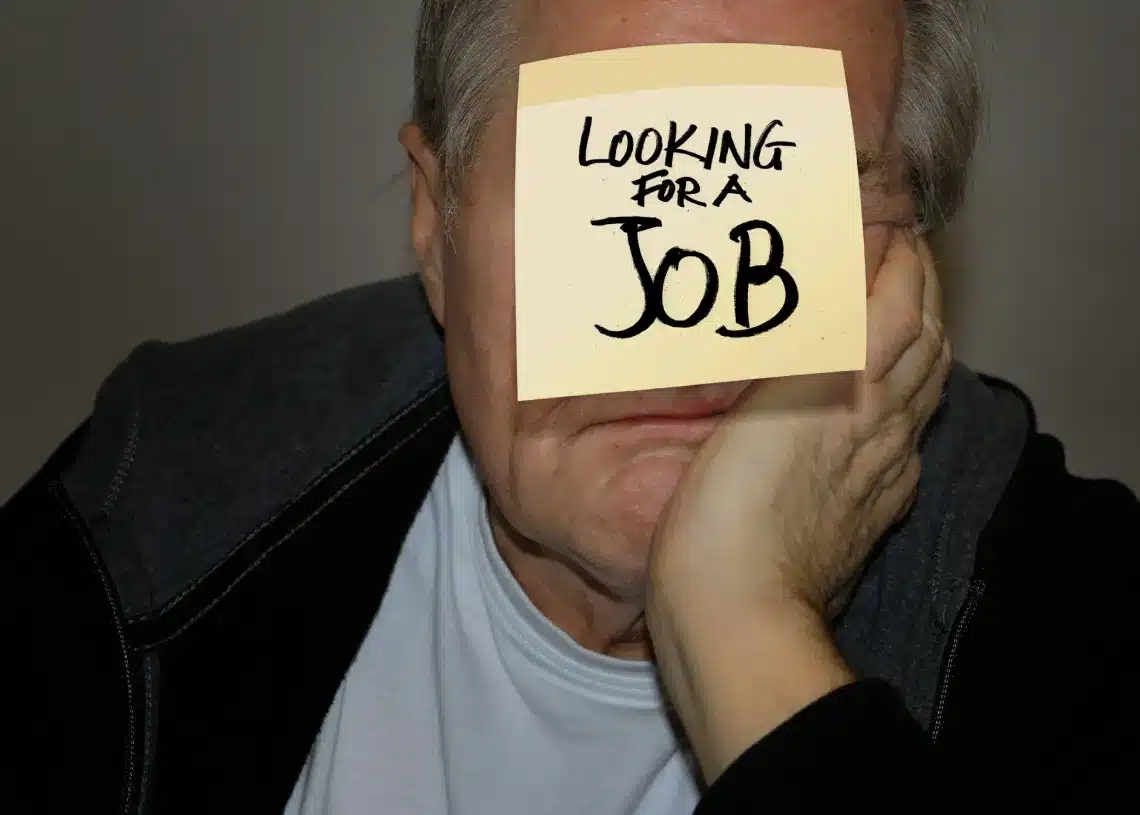 Fyring er positivt og giver nye muligheder - mand med papir på panden - leder efter et nyt job