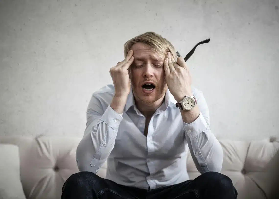 hjælp min leder er psykopat stærkt påvirket mand i sofa og holder sig til hovedet